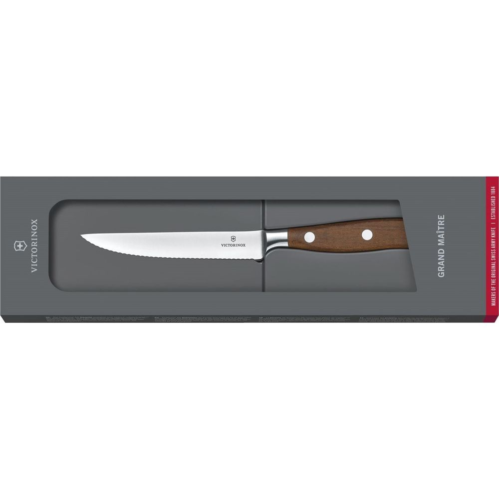Ein Victorinox Grand Maître Messer mit Wellenschliff und Holzgriff in Verpackung.