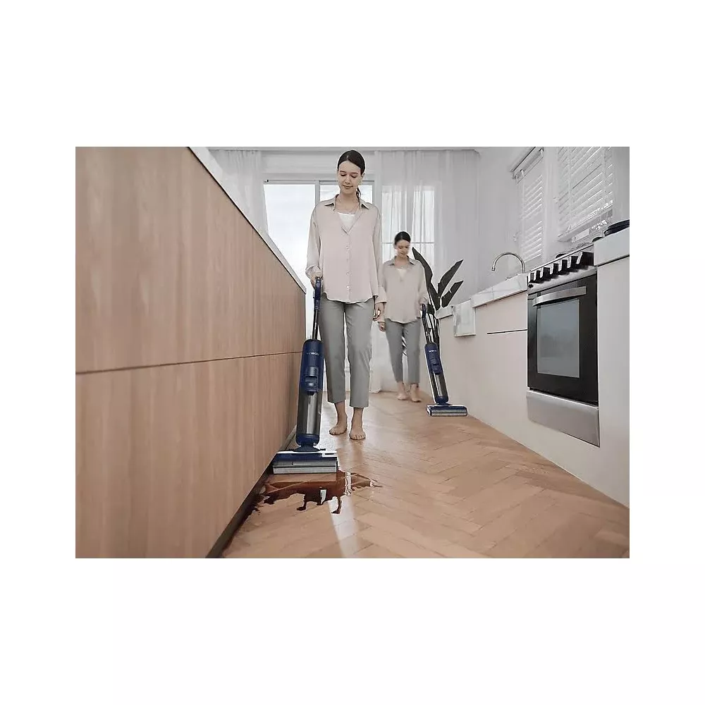 Dwie kobiety czyszczą drewnianą podłogę w kuchni odkurzaczami na mokro/sucho.