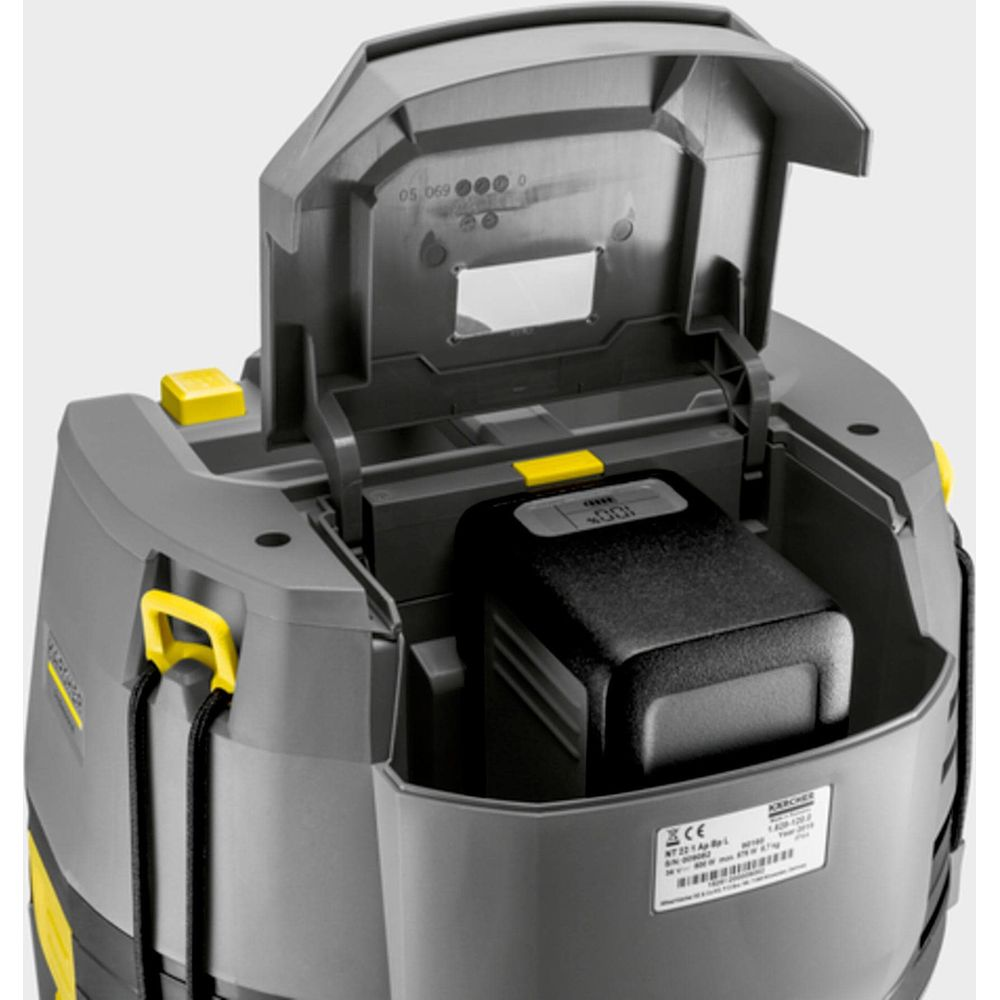 Aspirapolvere Kärcher grigio con coperchio aperto, batteria nera visibile.