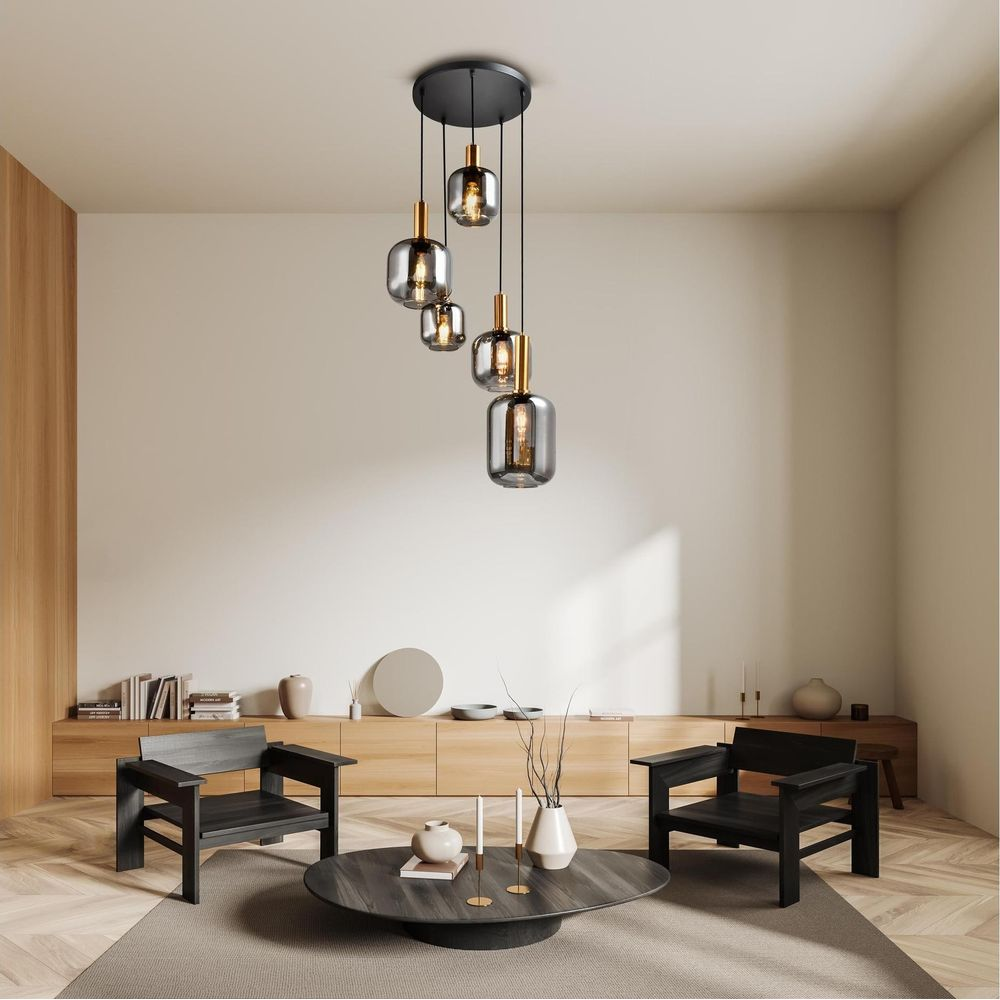 Un salon avec cinq suspensions, deux fauteuils noirs et une table basse.