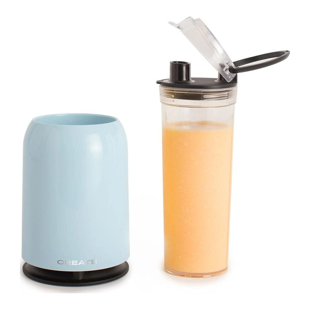Ein hellblauer Becher neben einem Glas mit orangefarbenem Smoothie.
