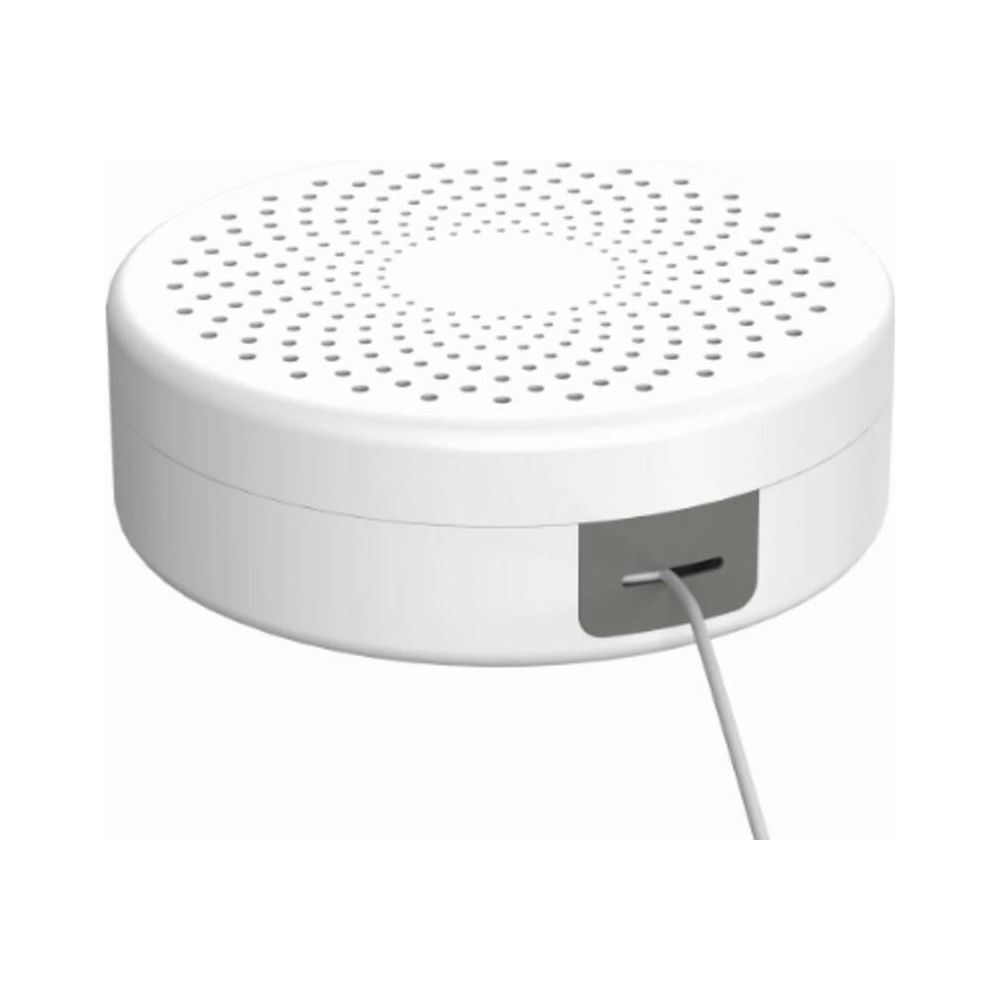 Un dispositivo bianco e rotondo con fori di ventilazione e un cavo inserito.
