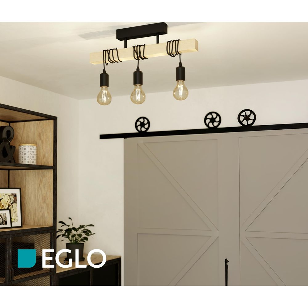 Luminaire en bois à trois ampoules au-dessus d'une porte coulissante.