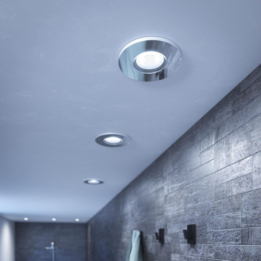 Een moderne badkamer plafondspot met zilveren rand op een grijs plafond.