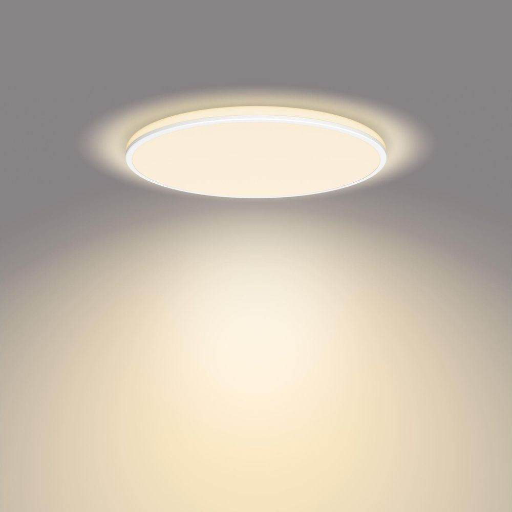 Un plafonnier rond émettant une lumière chaude sur un plafond gris.