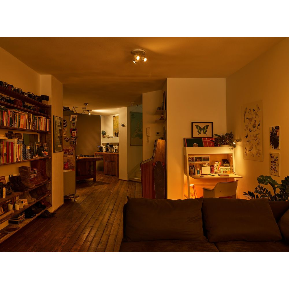 Un salon avec une bibliothèque, un bureau, un canapé et un jeu d'arcade.