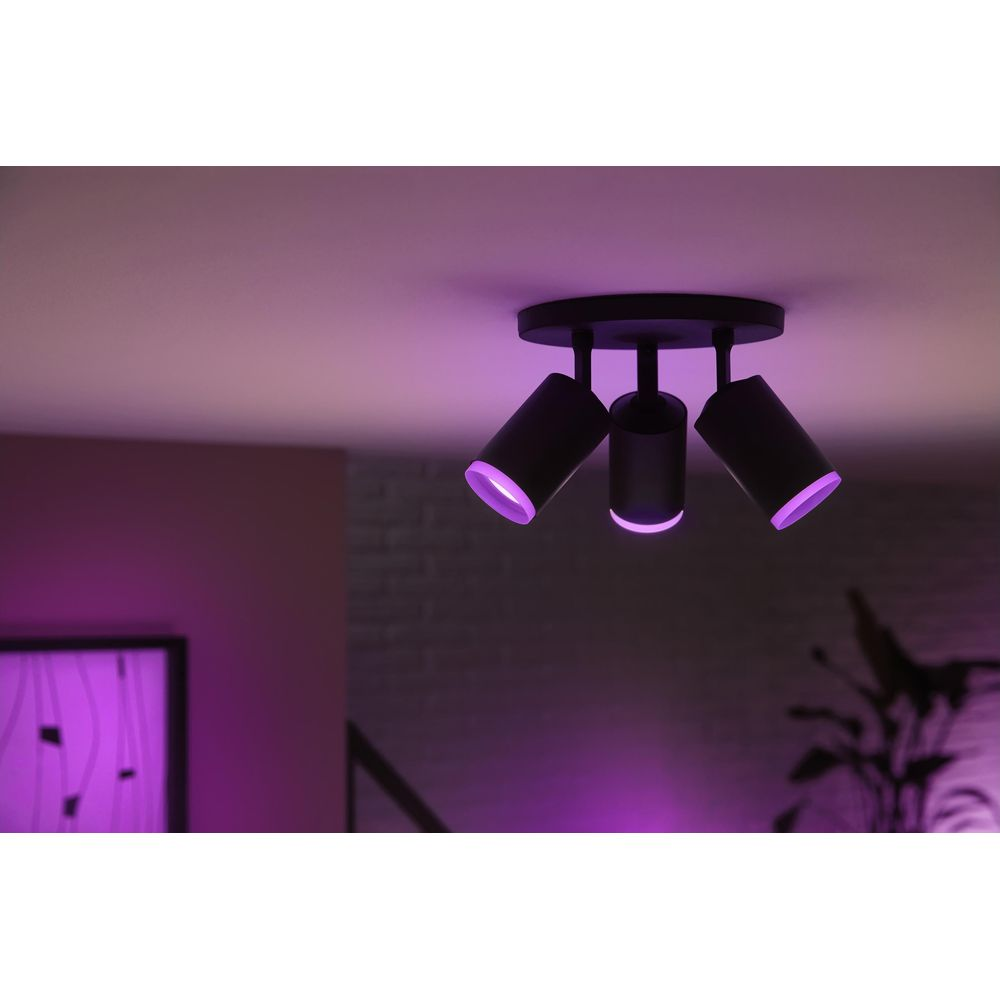 Plafonnier noir avec trois lampes émettant une lumière violette.