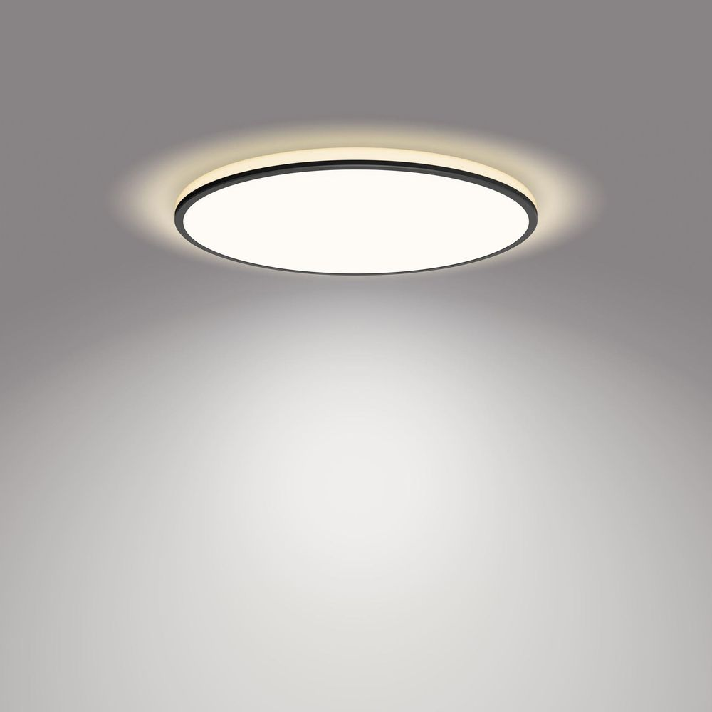 Un plafonnier rond et simple avec un bord noir et un éclairage chaleureux.