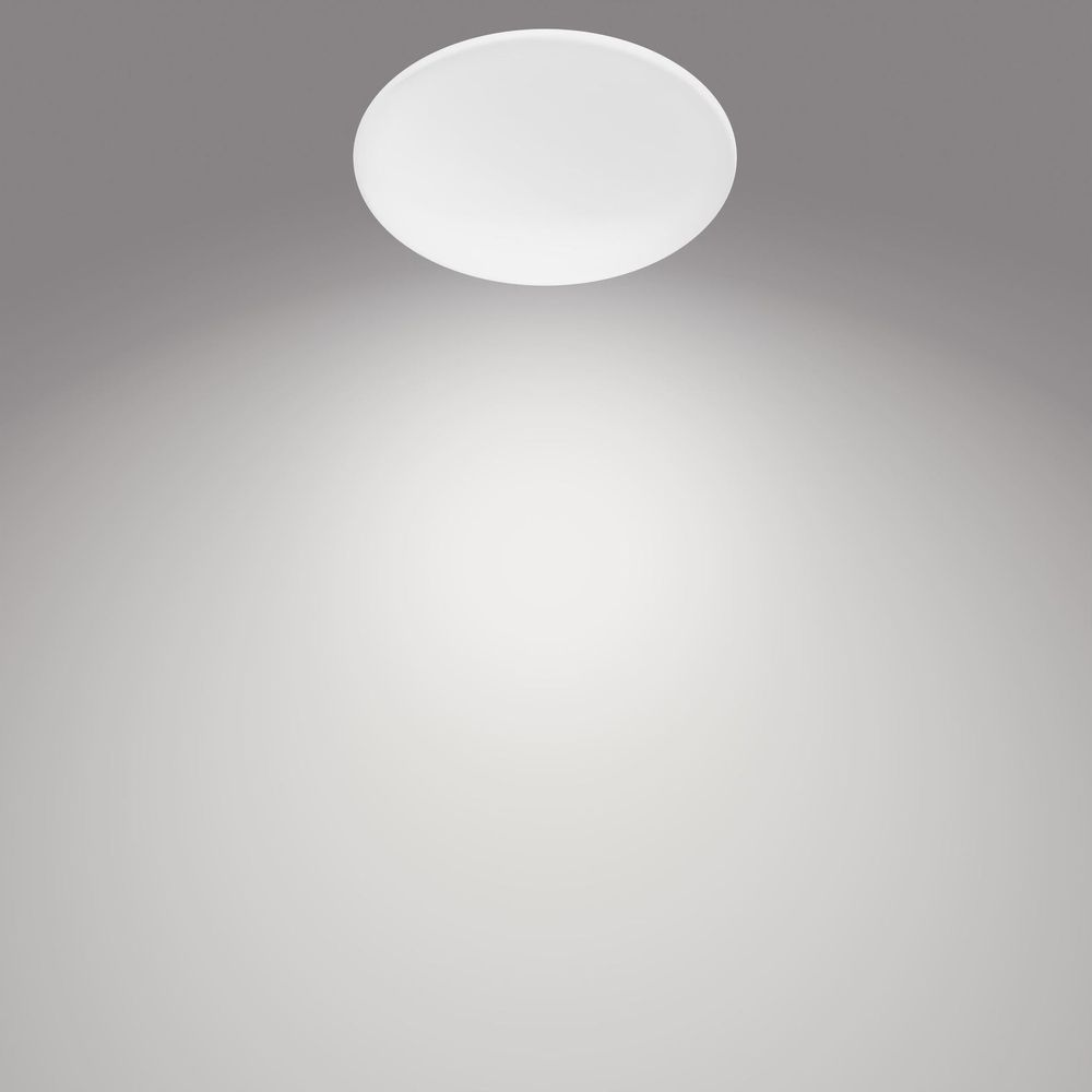 Una luz de techo redonda y blanca ilumina un fondo gris.