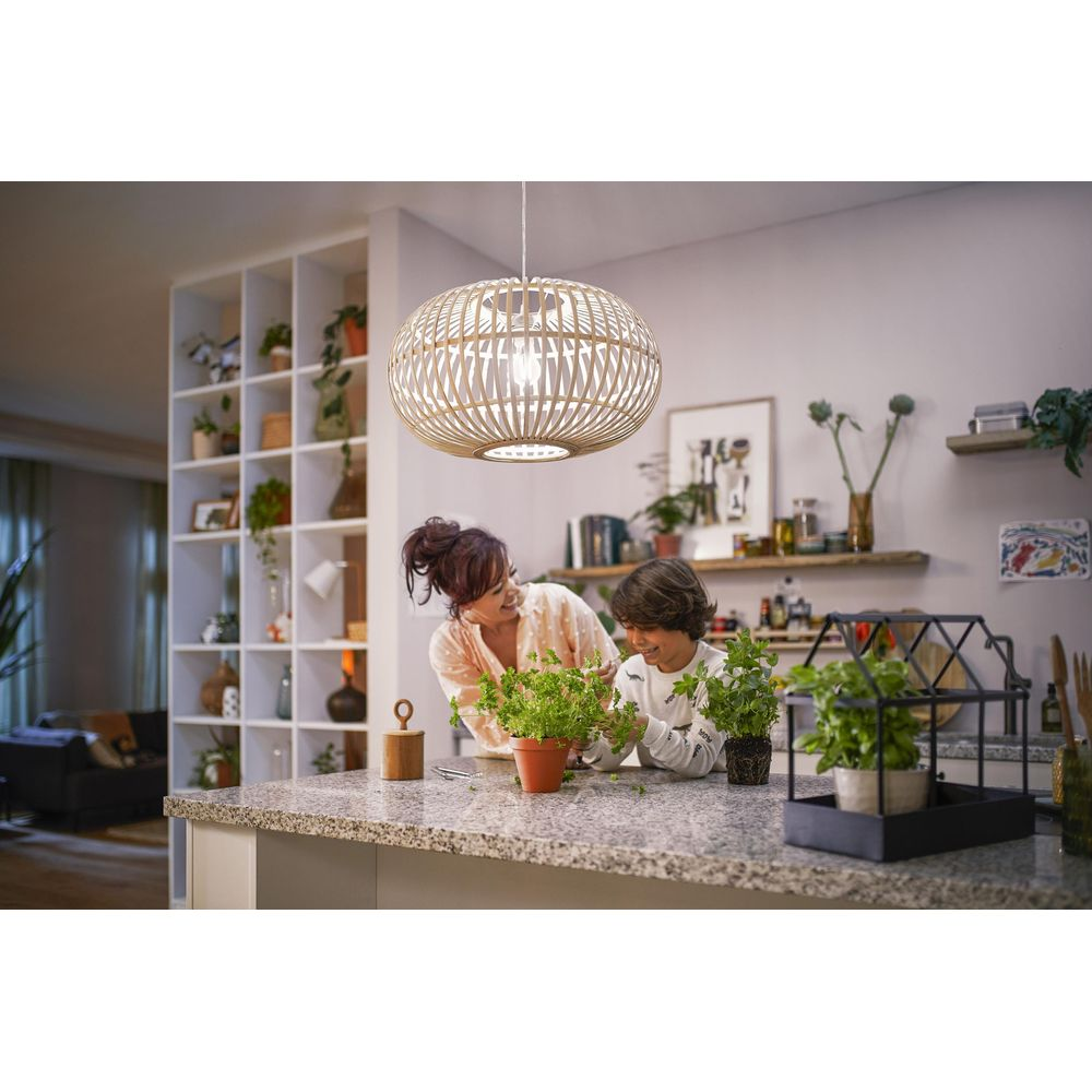 Kobieta i dziecko pielęgnują rośliny przy blacie kuchennym pod drewnianą lampą.