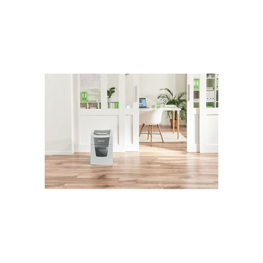 Une déchiqueteuse blanche sur un plancher de bois devant un bureau.