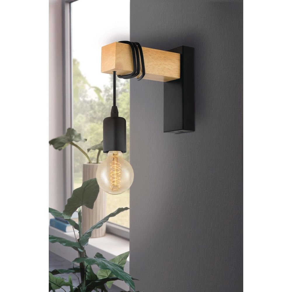 Lampada da parete in legno e metallo nero con lampadina.