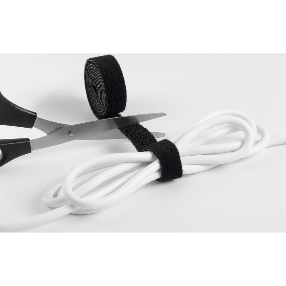 Eine Schere schneidet schwarzes Klettband um weiße Kabel.