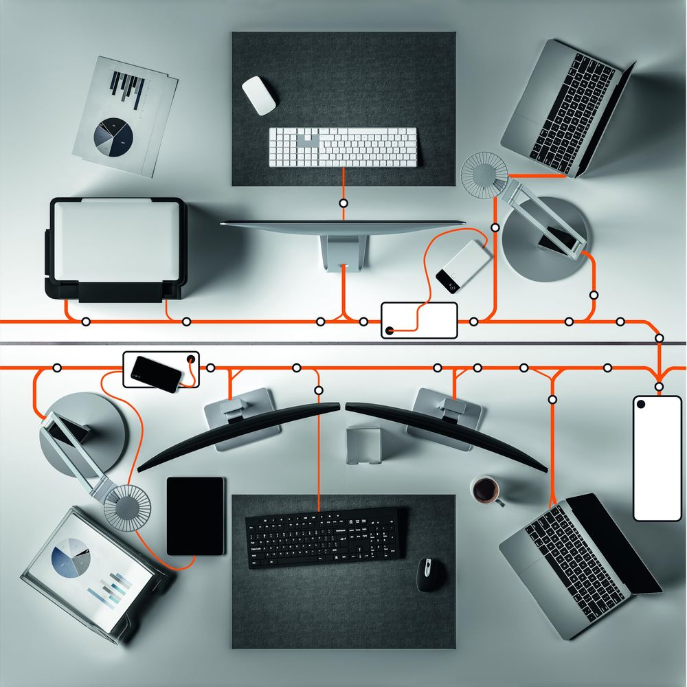 Büroarbeitsplatz mit zwei Monitoren, Laptops, Tastaturen, Mäusen, Smartphones und Kaffee.