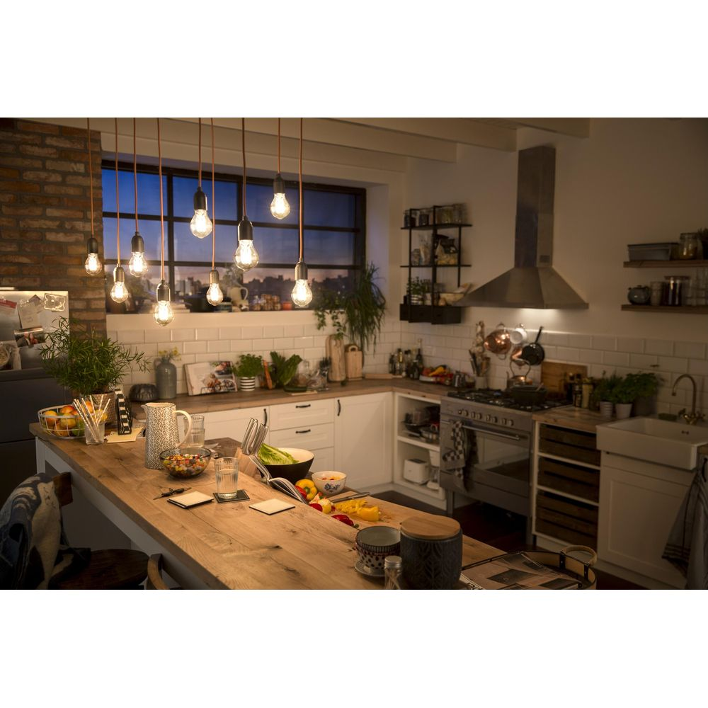 Una cucina rustica con isola in legno, luci a sospensione e vista finestra al tramonto.