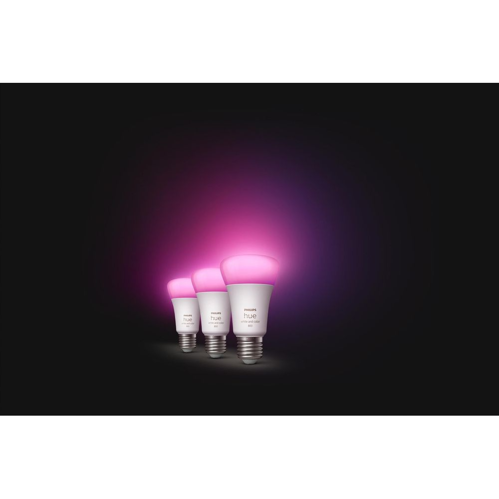 Trois ampoules Philips Hue brillent en rose sur fond sombre.