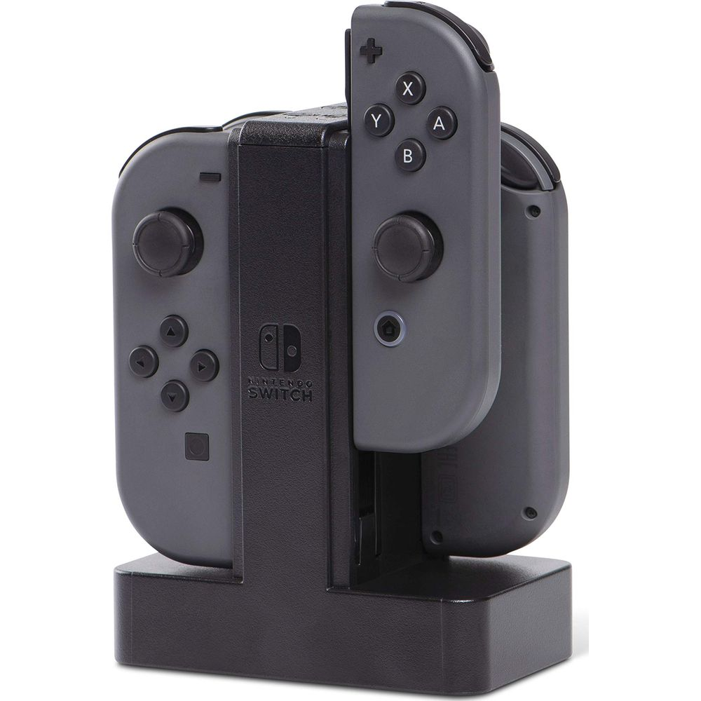 Controller Joy-Con grigi Nintendo Switch in carica in una base di ricarica nera.