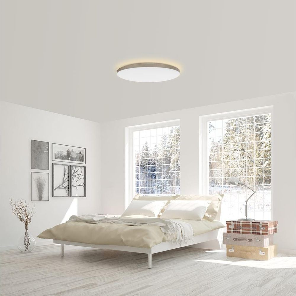 Ein Schlafzimmer mit Bett, Bildern an der Wand und Fenstern mit Schnee.
