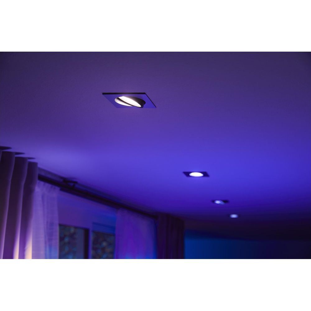 Verschillende vierkante inbouwspots met blauw licht aan het plafond.
