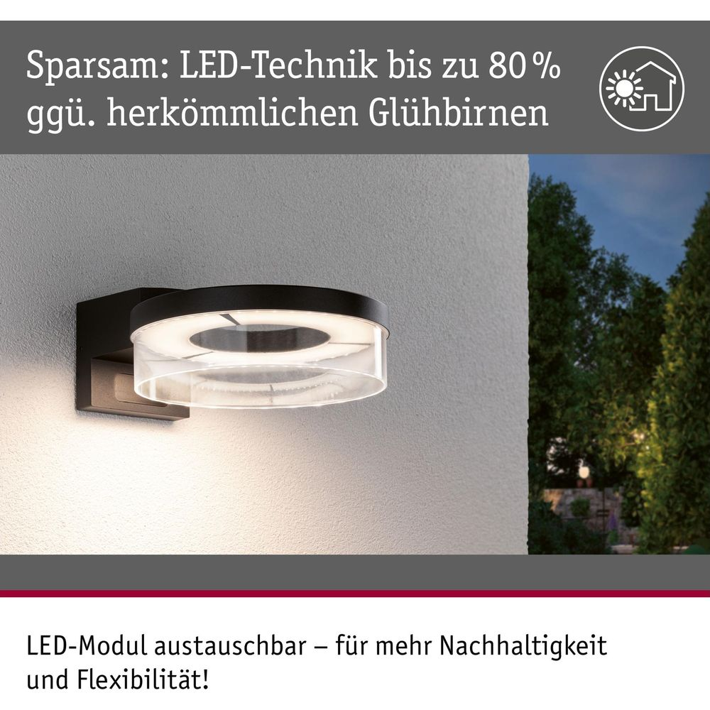 Nowoczesna czarna lampa ścienna z okrągłym światłem LED, zamontowana na ścianie.