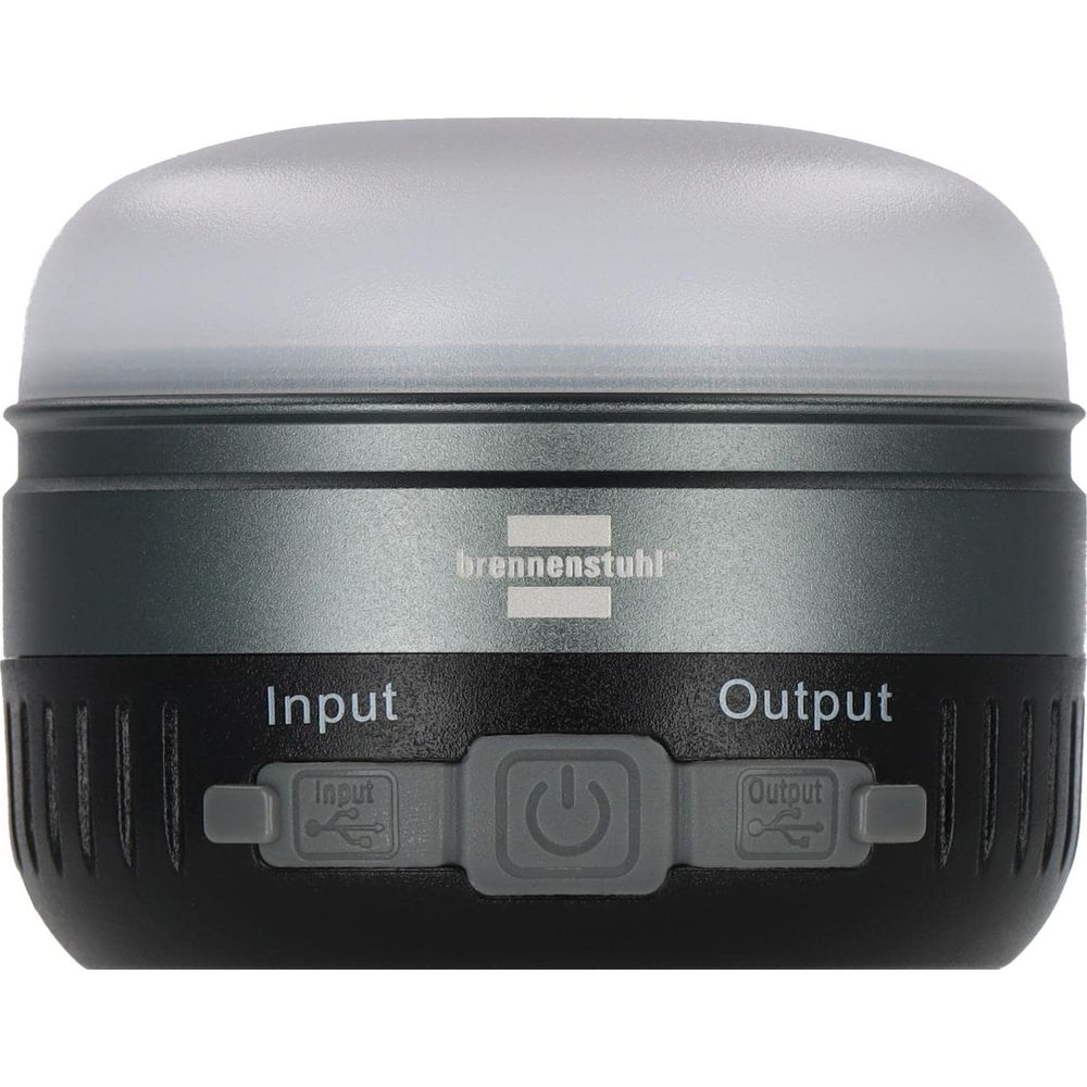 Kompaktowa latarnia z czarnym korpusem i srebrnym paskiem. Etykiety: Input, Output.