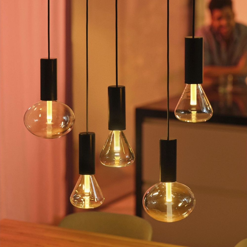 Pięć wiszących żarówek z czarnymi oprawkami, niektóre okrągłe, inne w kształcie łzy.