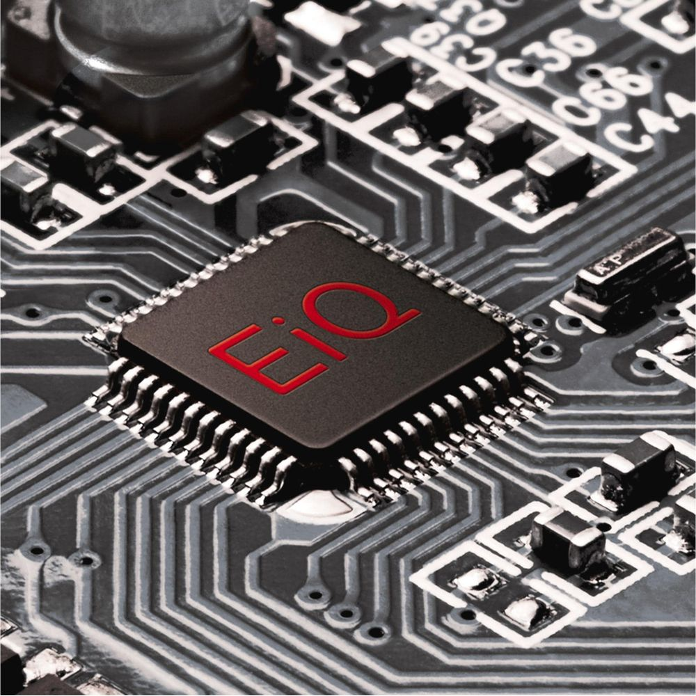 Une puce noire avec un logo rouge sur une carte de circuit imprimé avec de nombreux petits composants.