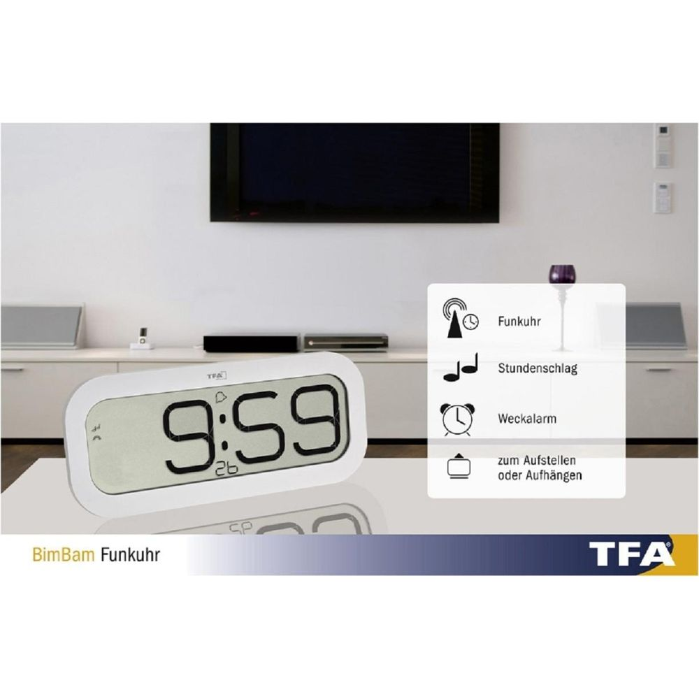 Digitaluhr zeigt 9:59. Im Hintergrund ein Wohnzimmer mit Fernseher.