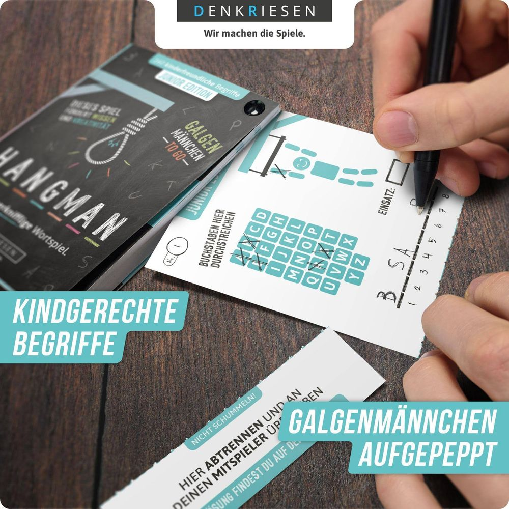 Person spielt Galgenmännchen mit Kindern. Stift und Spielkarten liegen auf dem Tisch.