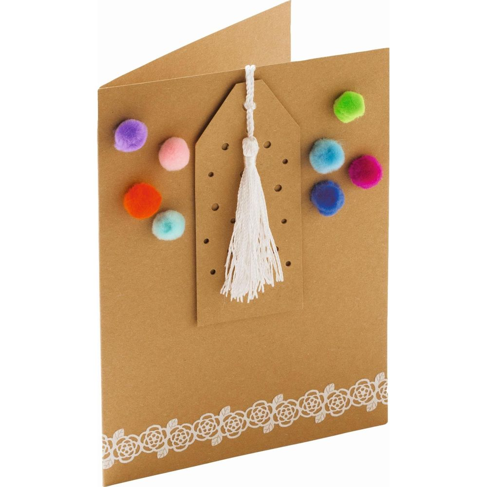 Braune Karte mit bunten Pompons und Quaste, mit Blumenband verziert.