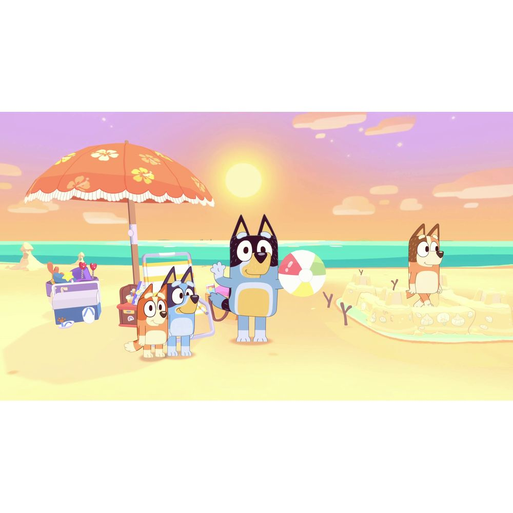 Familie auf einem sonnigen Strand mit Sandburg und Ball.