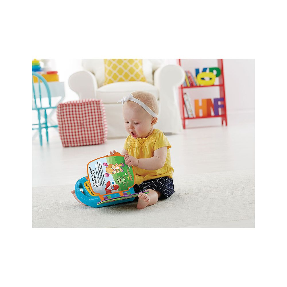 Ein Baby sitzt auf dem Boden und spielt mit einem bunten Buch.