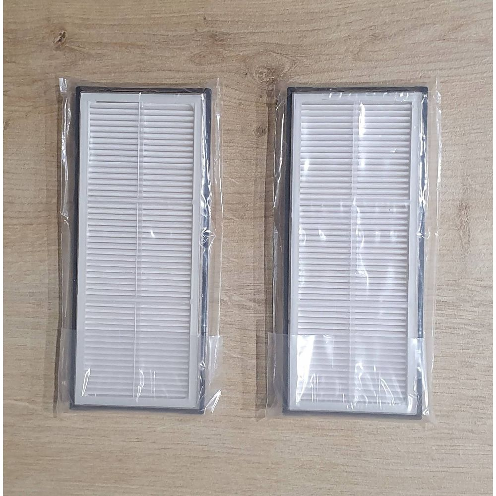 Deux filtres à air blancs sous emballage plastique sur fond de bois.