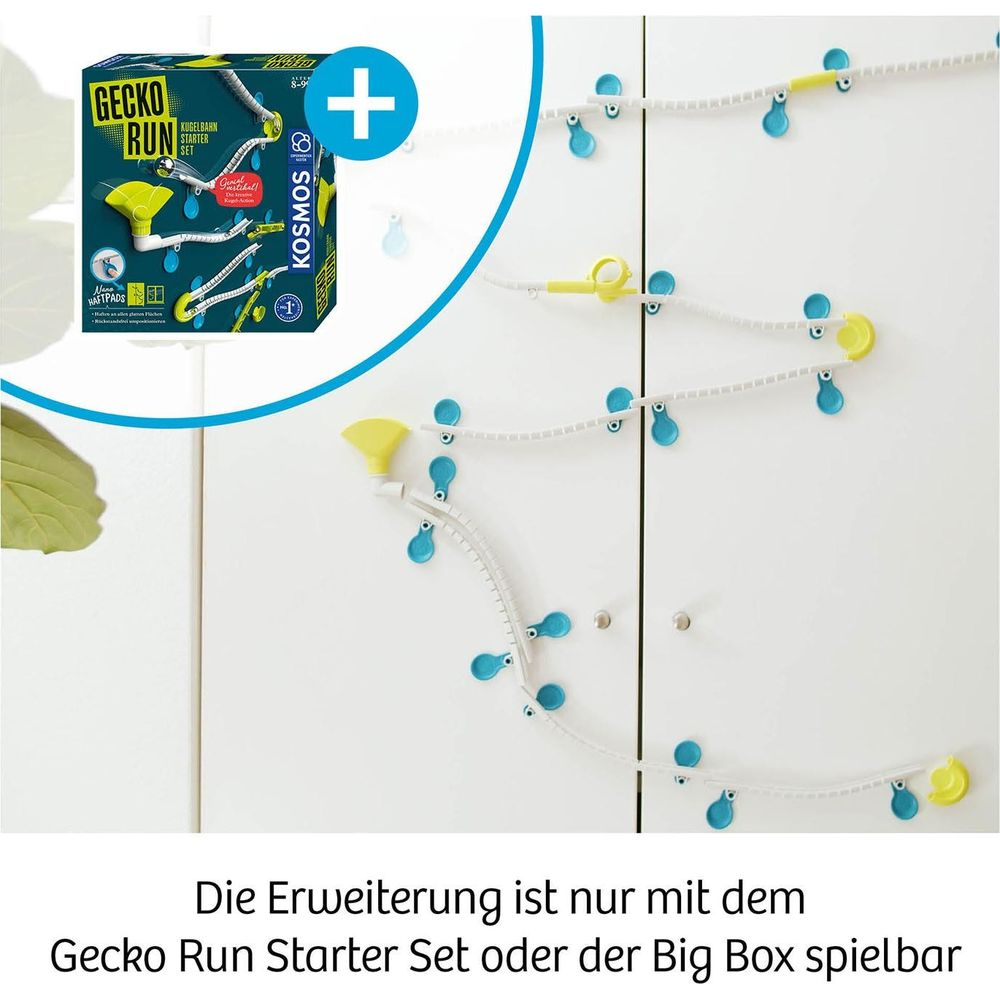 Gecko Run Kugelbahn-Set mit blauen und gelben Elementen an einer weißen Wand.