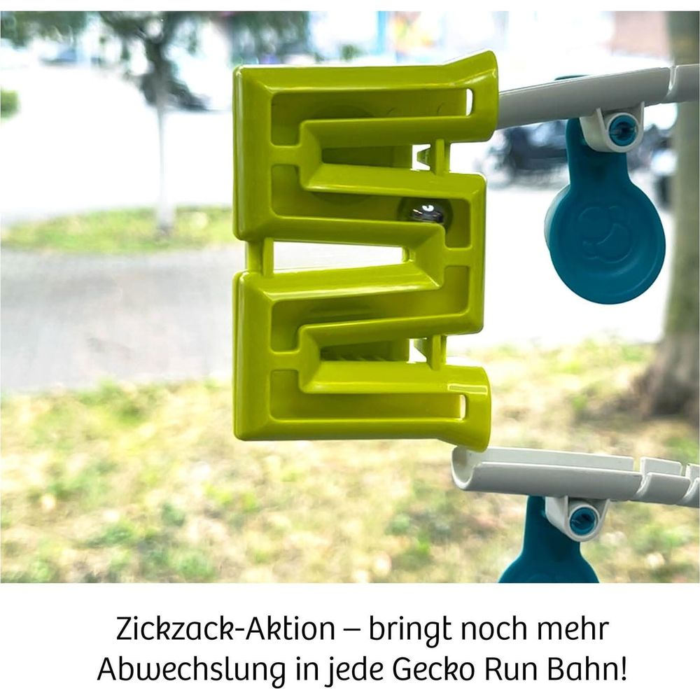 Eine grüne Zickzackbahn mit Ball sitzt auf einer Schiene. Ein blauer Spinner ist befestigt.