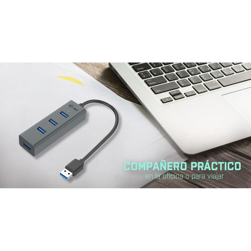 Gray USB hub with cable next to a laptop on paper.