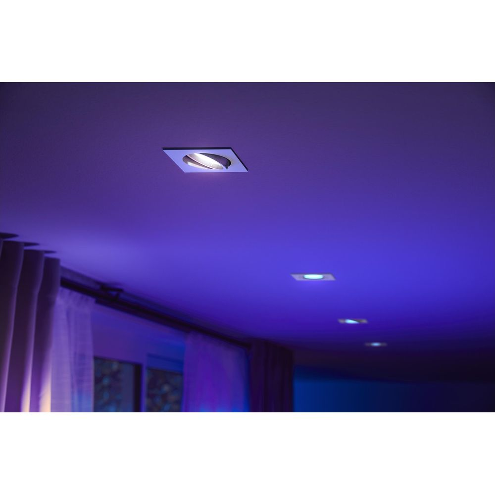 Inbouwspots werpen blauwe verlichting op het plafond en gordijnen.