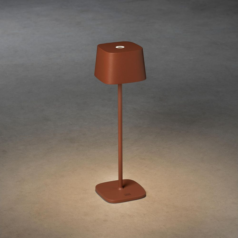 Eine braune Tischlampe mit einem quadratischen Fuß und Lampenschirm.