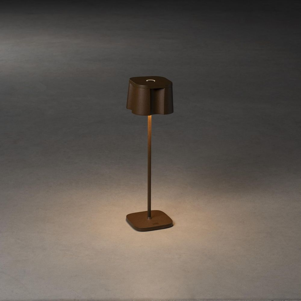 Eine braune Tischlampe mit einem quadratischen Sockel und einem schirmförmigen Lampenkopf.