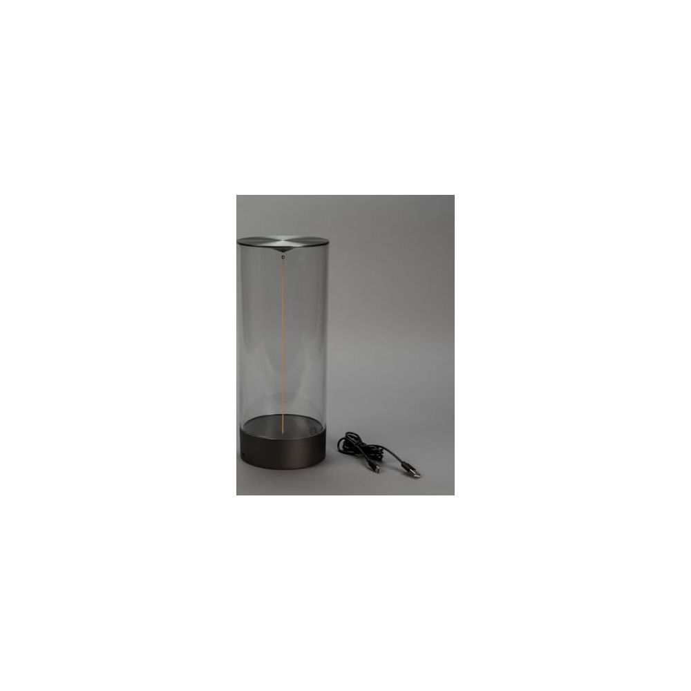 Eine zylindrische Lampe mit dunklem Sockel und transparentem Glaszylinder.