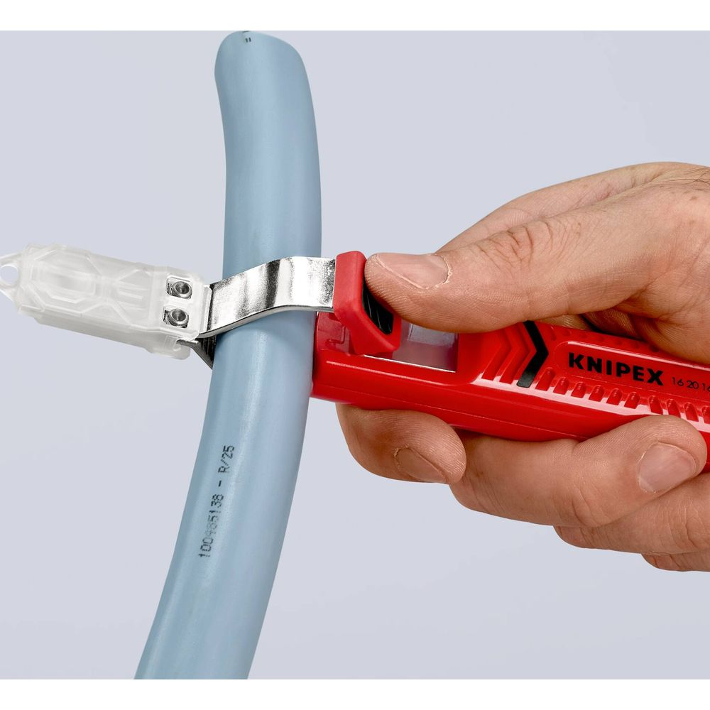 Eine Hand hält einen roten Rohrabschneider, der einen blauen Schlauch schneidet.