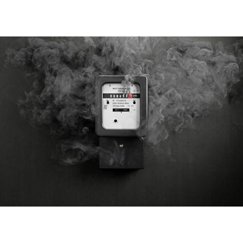 Un contatore di wattora circondato da fumo su sfondo scuro.