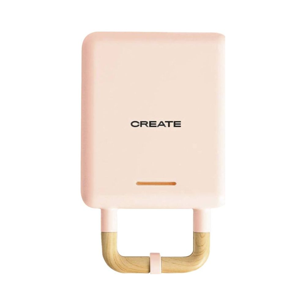 Una sandwichera rosa con asas de madera y la palabra "CREATE".