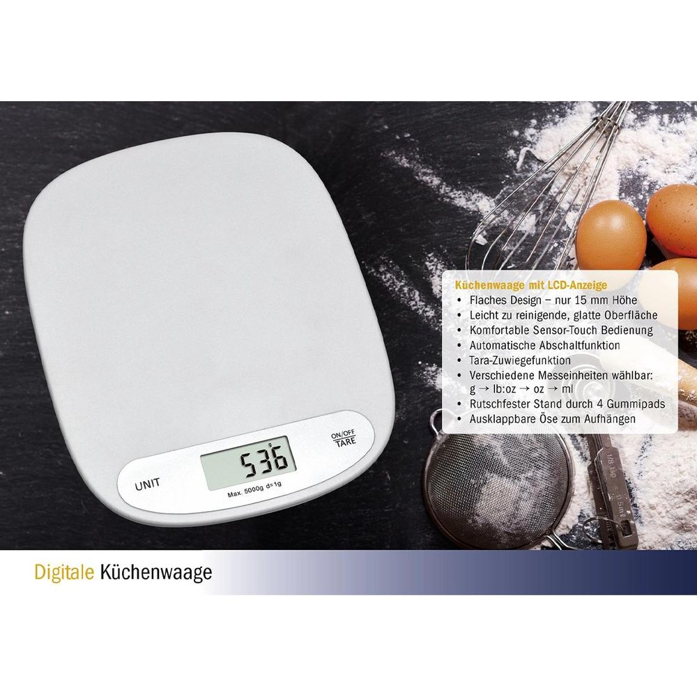Weiße Küchenwaage mit LCD-Display, daneben Eier, Schneebesen und Sieb.