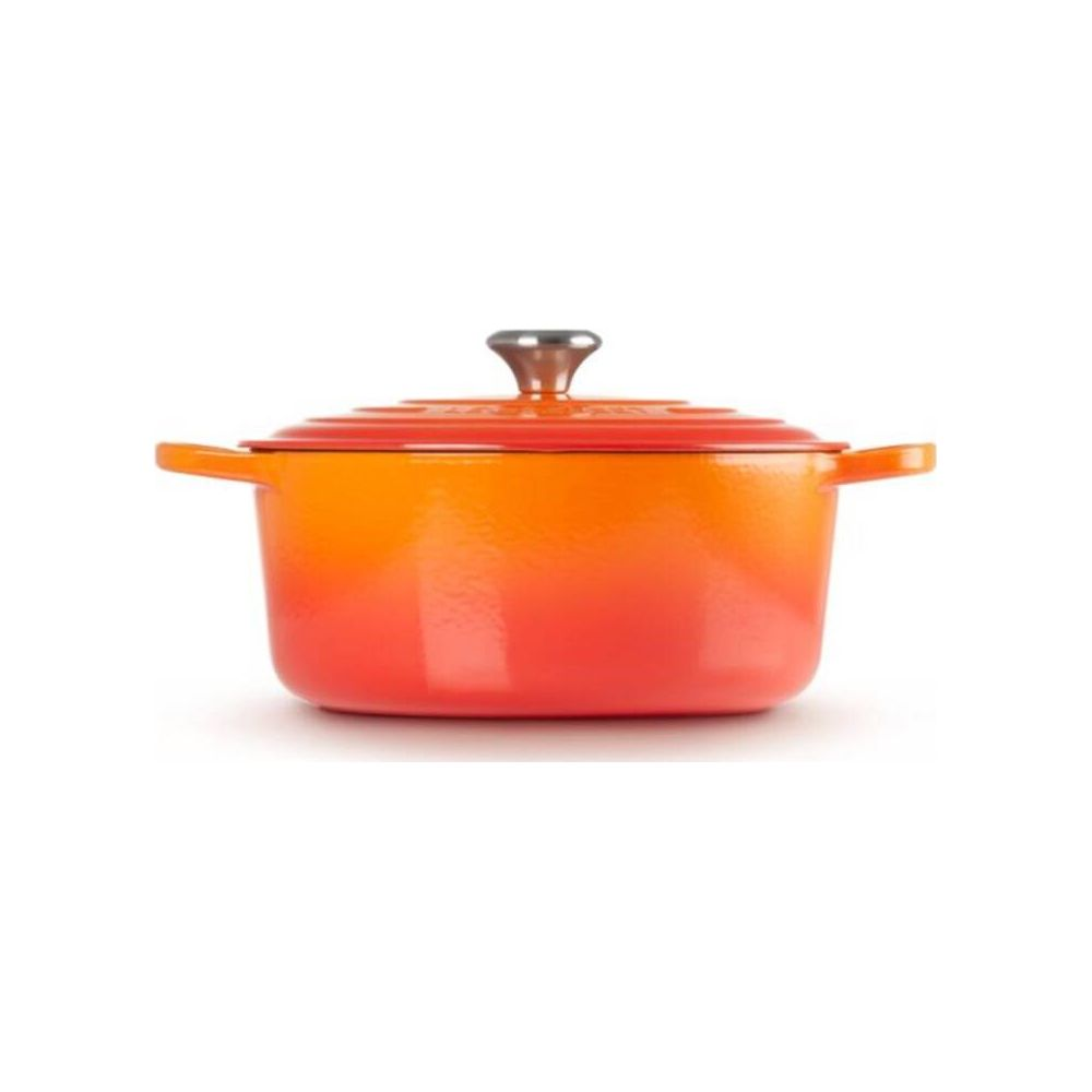 Pomarańczowo-czerwony garnek żeliwny z pokrywką i uchwytami na białym tle.