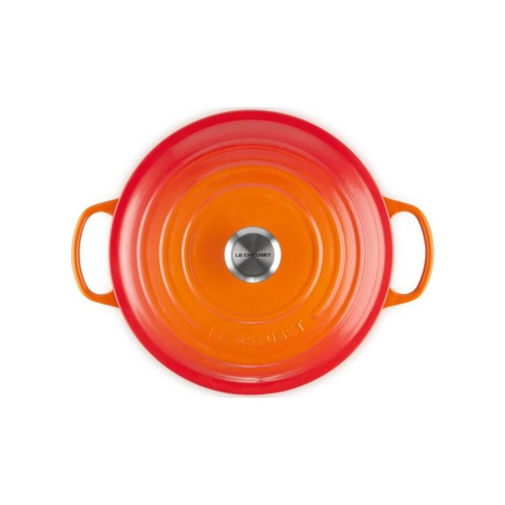 Okrągły, pomarańczowo-czerwony garnek z uchwytami i srebrnym pokrętłem na pokrywie.