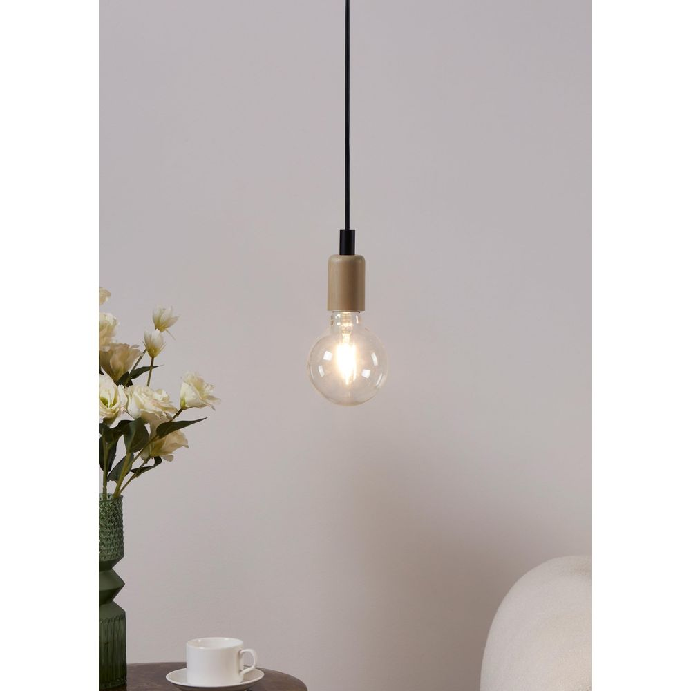 Une ampoule pend à un fil avec un support beige. À gauche, un vase avec des fleurs et une tasse.