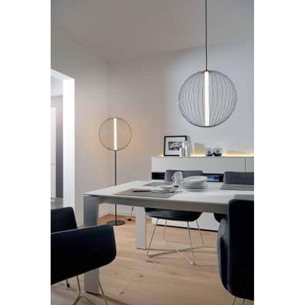 Salle à manger moderne avec suspension ronde et lampadaire.