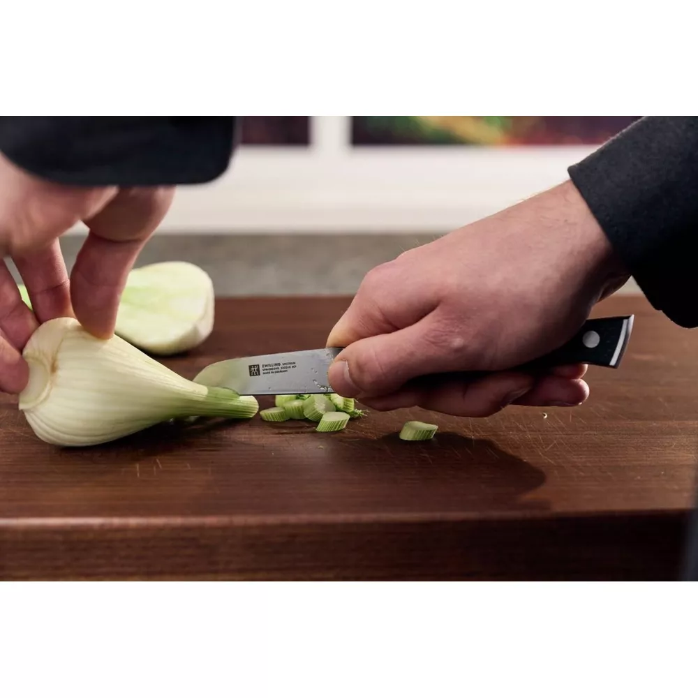 Koper włoski jest krojony w plasterki na drewnianej desce do krojenia.