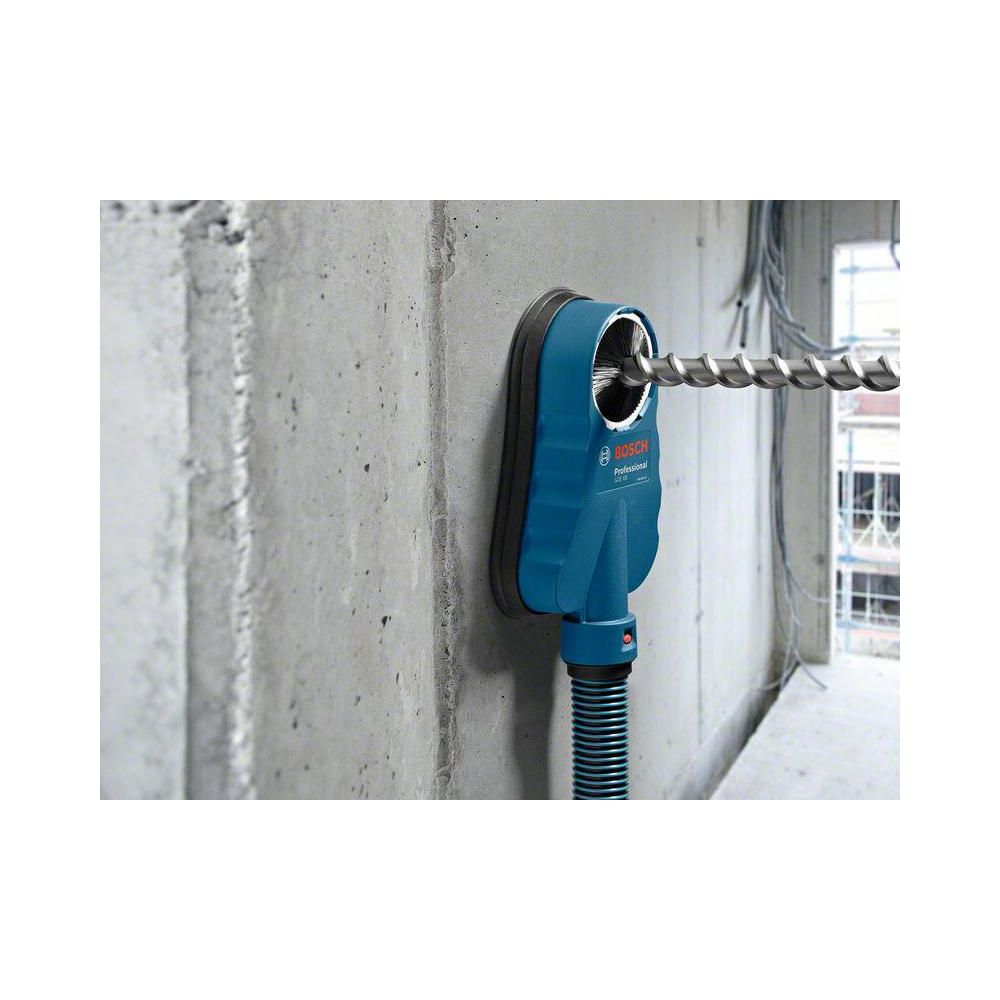 Blauer Bosch-Bohrschmutzfänger mit Bohrer an Betonwand.